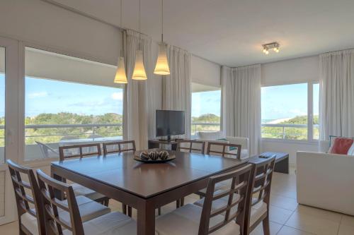 uma sala de jantar com uma mesa e cadeiras e uma televisão em Valeria Playa Apart em Valeria del Mar