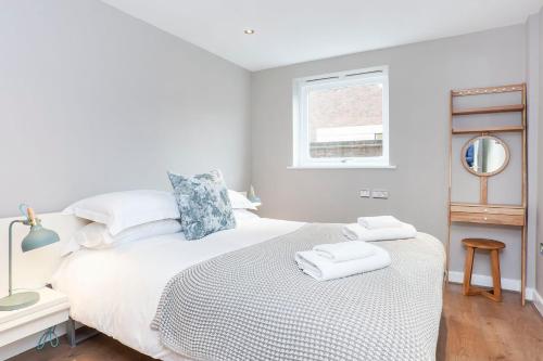 een witte slaapkamer met een bed met twee handdoeken erop bij Bootham Retreat- Superb City Centre Hideaway-Free Parking in York