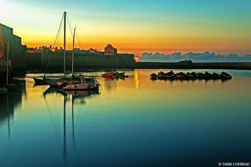 a group of boats sitting in the water at sunset at Art house in El Jadida