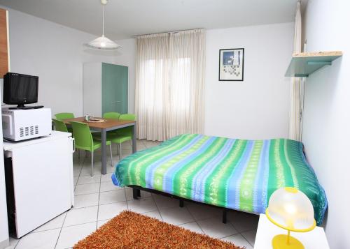 1 dormitorio con 1 cama y 1 mesa con sillas en Residence Stella Polare, en Bibione