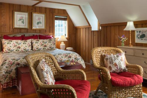 1 dormitorio con 1 cama y 2 sillas de mimbre en Inn and Cabins at Vaucluse Spring, en Stephens City