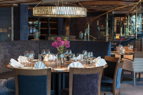 a dining room with a table with a vase of flowers at Holmen Fjordhotell in Nesbru