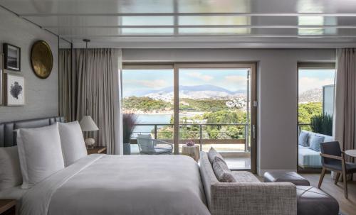 a hotel room with a bed and a large window at Four Seasons Astir Palace Hotel Athens in Athens