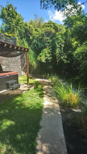 a pathway with a bench and trees and grass at Les Bambous in Petite Île