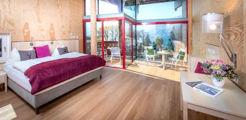 a bedroom with a large bed and a table and chairs at Der Erlhof Restaurant & Landhotel in Zell am See