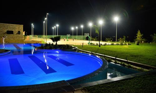 a swimming pool at night with lights in a park at EPIC Hotel & Suites in Nyagatare