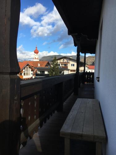 a bench sitting on a balcony with a view of a city at Landhaus Holzereck in Ehrwald