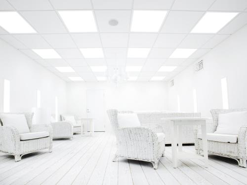 a room with white chairs and tables and a ceiling at Arken Hotel & Art Garden Spa in Gothenburg