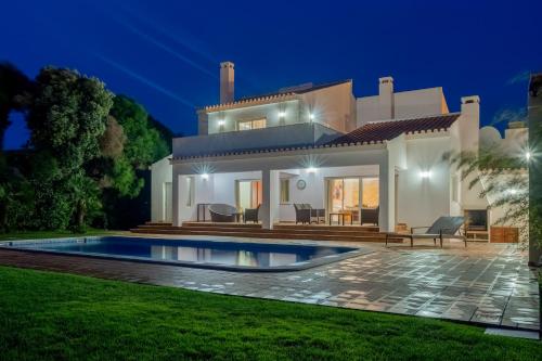 a villa with a swimming pool at night at Deslumbrante V6 in Casal da Lagoa Seca