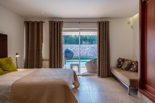 um quarto com uma cama, um sofá e uma janela em Deslumbrante V6 em Praia del Rei