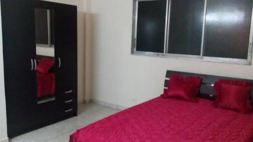 um quarto com uma cama vermelha e um armário preto em CHEZ MIMI em Gros-Morne