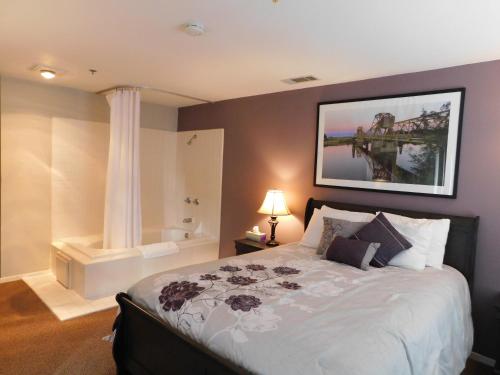 a bedroom with a large bed and a bath tub at Freeport Wine Country Inn in Freeport