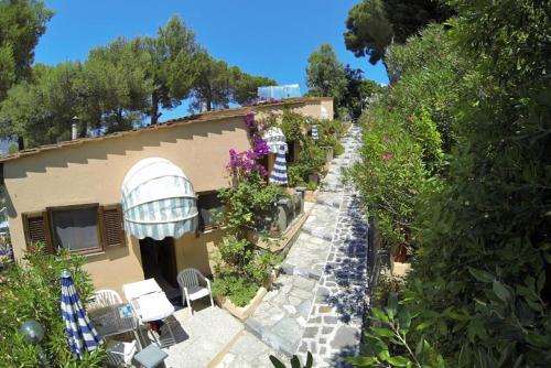a building with a garden with chairs and a building at Residence Vacanza Mare in Campo nell'Elba