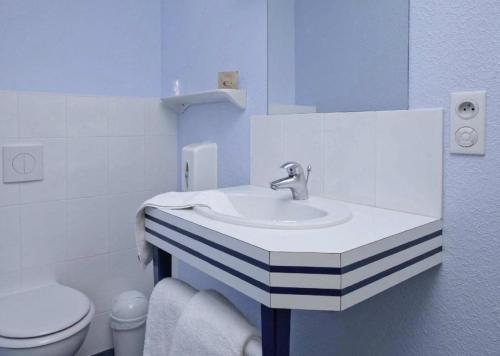 a bathroom with a sink and a toilet at Hôtel Estuaire in Saint-Brevin-les-Pins