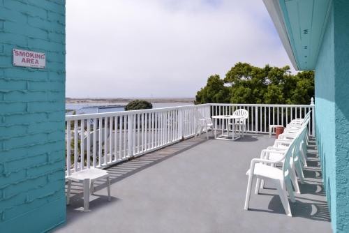 a balcony with chairs and a view of the water at Bay View Inn - Morro Bay in Morro Bay
