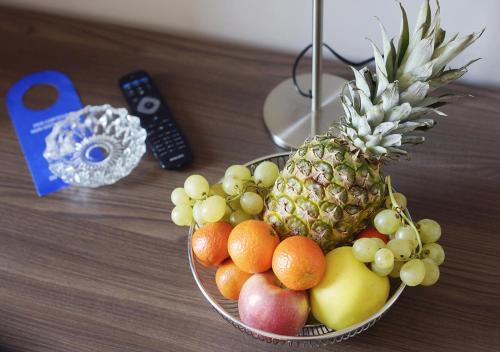 a bowl of fruit on a table with a remote control at Hotel Mediterranee in Genova