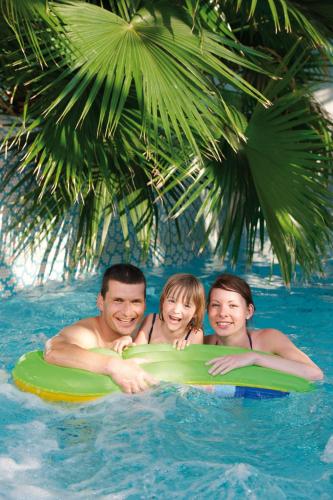 a man and two children on a raft in the water at Parkhotel Neustadt in Neustadt in Sachsen