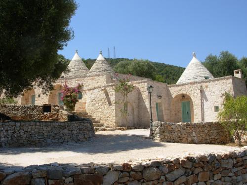 a stone building with turrets and a stone wall at Trulli La Zisa in Fasano