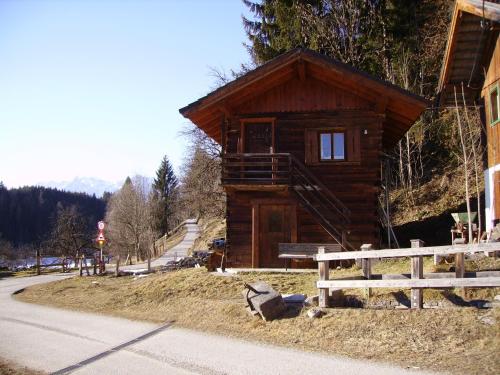 a small wooden cabin with a staircase on the side of a road at Ellmauhof in Pfarrwerfen