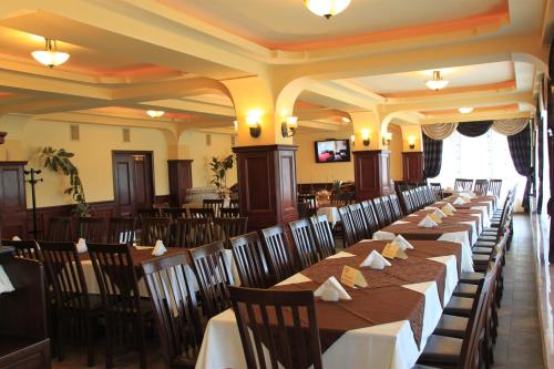 a row of tables and chairs in a restaurant at Pensiunea Vranis in Sadova