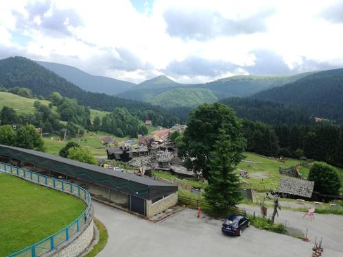 a car parked in a parking lot with mountains in the background at Apartmán Donovaly Šafrán 2 in Donovaly