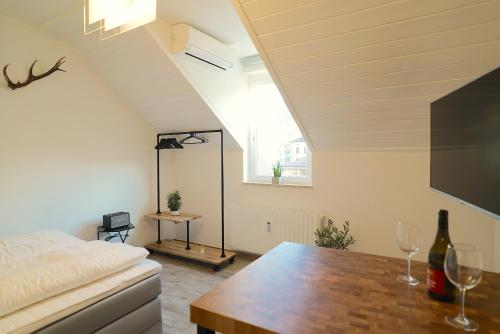 sala de estar con cama y mesa con copas de vino en Life Studio & City Bike, en Bolzano