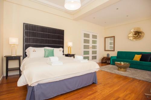 ポルトにあるML Apartments Charming Roomsのベッドルーム(大型ベッド1台、緑のソファ付)