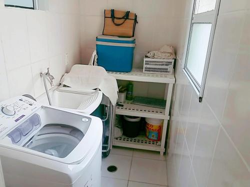 a laundry room with a washing machine in it at Apto Praia Bertioga - 3 dormitorios sendo uma suite in Bertioga