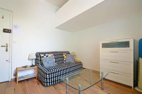 een woonkamer met een bank en een glazen tafel bij Le studio du Petit Palais Longchamp in Marseille