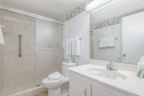 a bathroom with a toilet and a sink and a shower at Turtle Reef Club in Jensen Beach