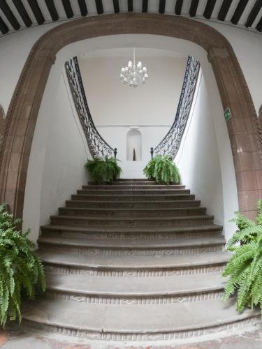 a set of stairs in a building with a chandelier at Markee Hotel Boutique in Querétaro
