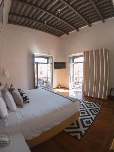 a large bedroom with a large bed and windows at Markee Hotel Boutique in Querétaro