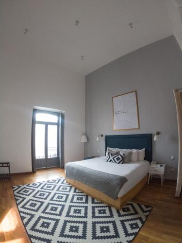 a bedroom with a large bed and a rug at Markee Hotel Boutique in Querétaro