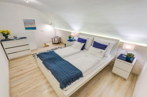 Dormitorio blanco con cama grande y almohadas azules en Beautiful Apartment at Basilica, en Budapest