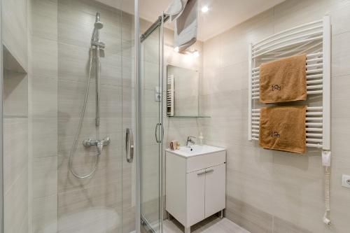 a white bathroom with a shower and a sink at Lovely Apartment at Basilica in Budapest