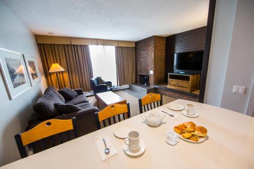 a living room filled with furniture and a tv at Jasper Inn & Suites in Jasper