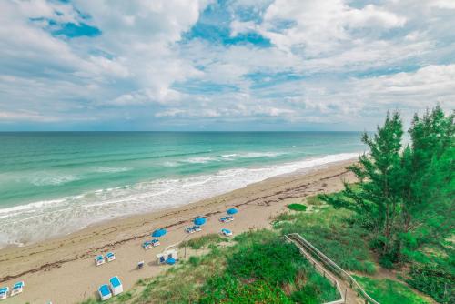 an aerial view of a beach with umbrellas and the ocean at Turtle Reef Club in Jensen Beach
