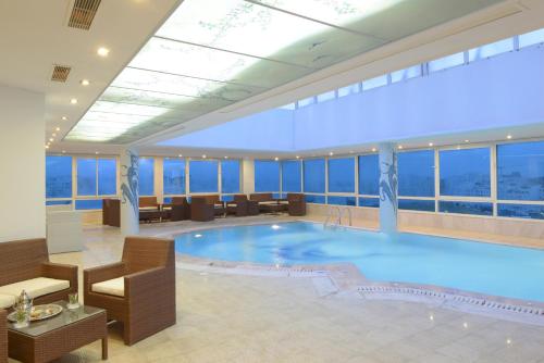 een groot zwembad in een hotellobby met ramen bij The Penthouse Suites Hotel in Tunis