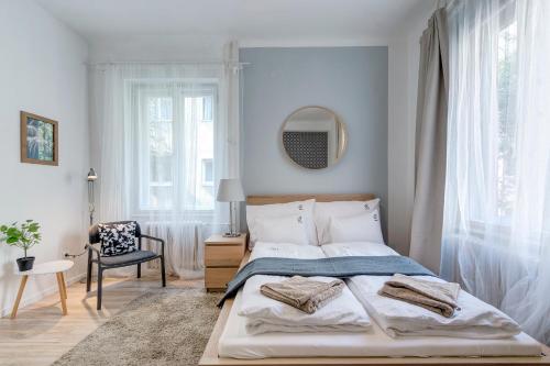 a bedroom with a bed and a chair and a mirror at Gálya Apartment in Budapest