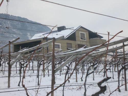 a house in the snow with snow covered roofs at Biobauernhof St. Quirinus in Caldaro