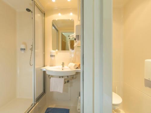 a bathroom with a sink and a shower and a toilet at Hotel Gasthof Stefansbrücke in Innsbruck