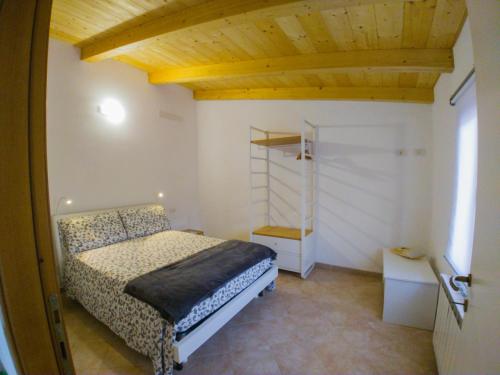 - une chambre avec un lit et un plafond en bois dans l'établissement Appartamento Il Fattore, à Levanto