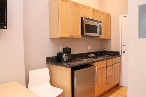 a kitchen with wooden cabinets and a stainless steel refrigerator at Furnished Studio in the South End #4 in Boston