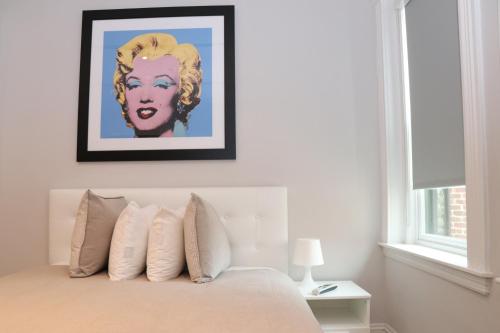 een slaapkamer met een bed met een schilderij aan de muur bij A Stylish Stay w/ a Queen Bed, Heated Floors.. #31 in Brookline
