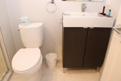uma casa de banho com um WC branco e um lavatório. em A Stylish Stay w/ a Queen Bed, Heated Floors.. #31 em Brookline