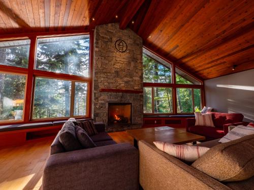 a living room with a stone fireplace in a house at The Cabins at Terrace Beach in Ucluelet