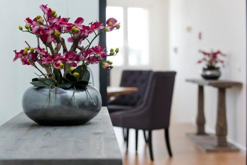 a vase filled with pink flowers sitting on a table at Days Inn Dessau in Dessau