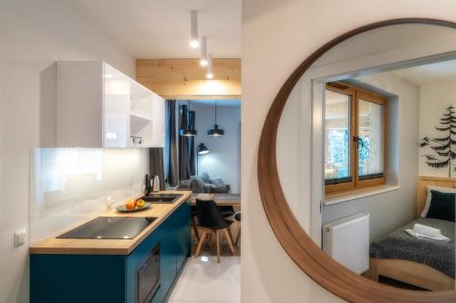 a kitchen with a sink and a mirror at Nosal Apartment in Zakopane