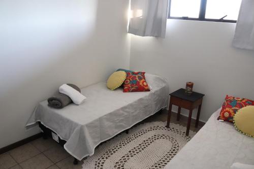 a room with a bed with pillows and a table at Edifício José Augusto in Betim