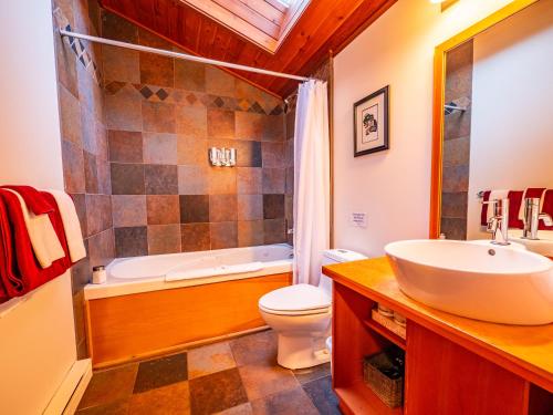 a bathroom with a sink and a tub and a toilet at The Cabins at Terrace Beach in Ucluelet
